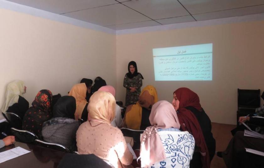 A group of women sitting in a room while one women presents.