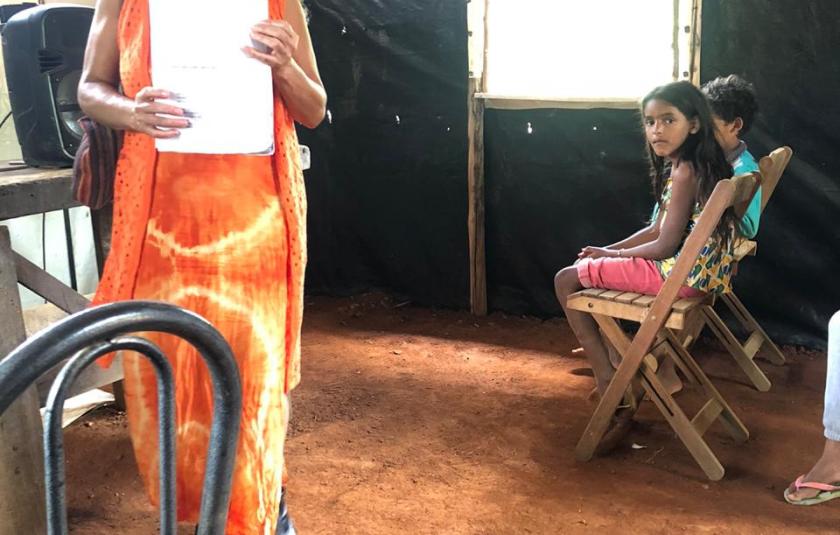 Photo: Teacher Maria Oliva helping the children with their homework. 