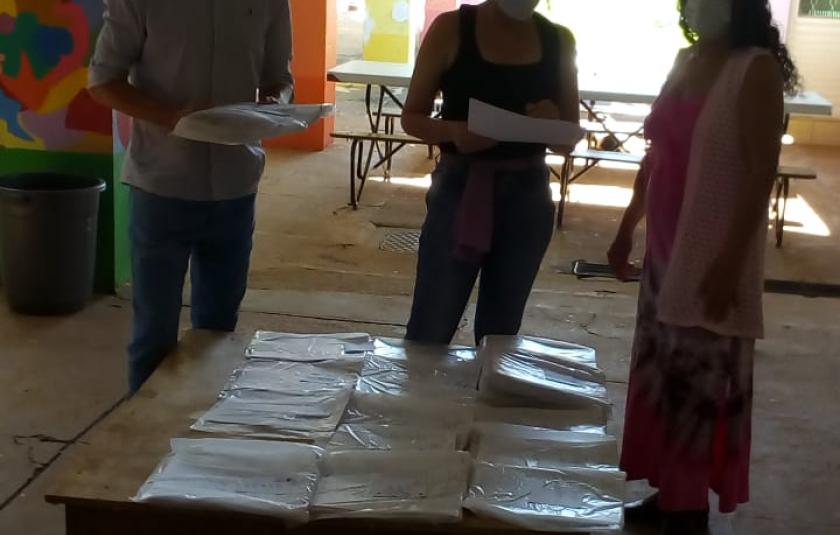 Photo: Teacher Maria Oliva delivering the school material to the children 