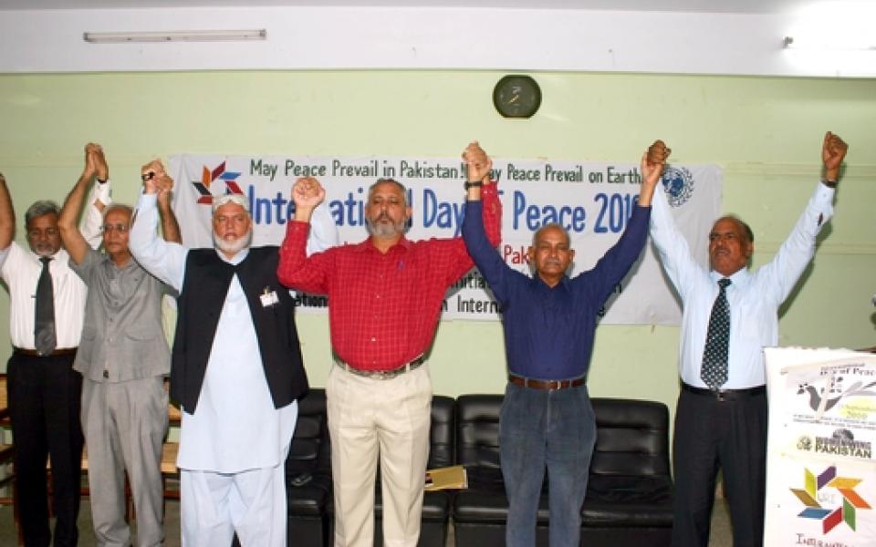 people of different faiths are holding hands up together