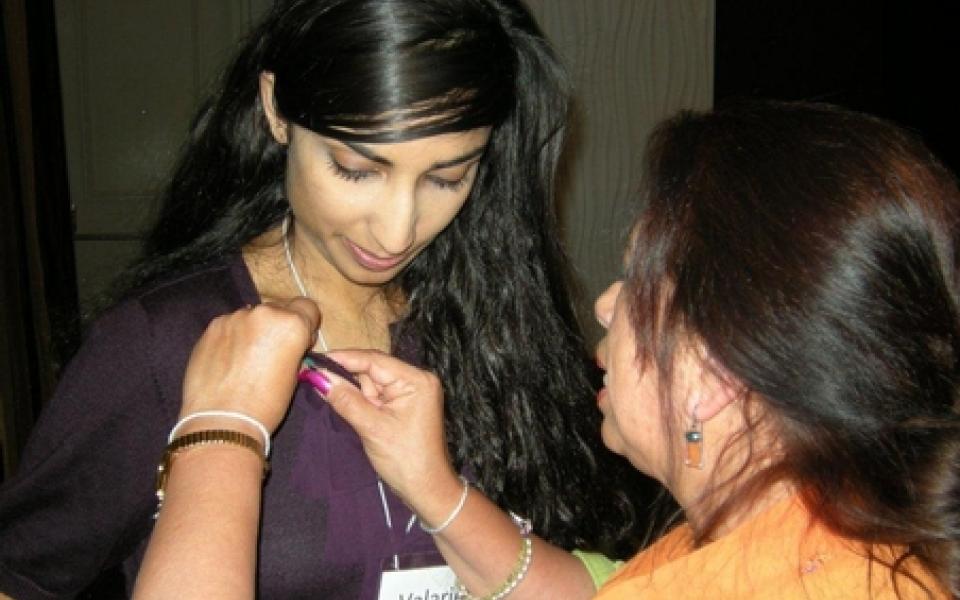 Yoland pinning the URI star on the hosted speaker
