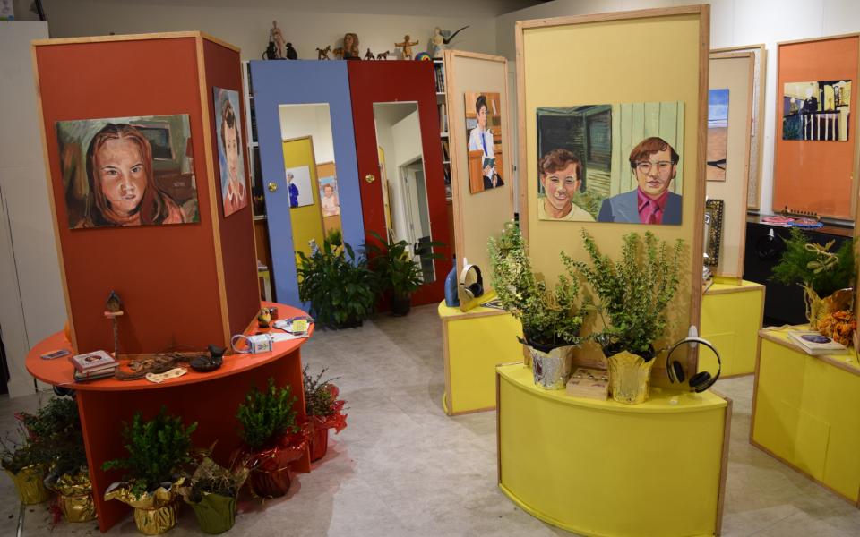 Picture: A display of paintings of people in a gallery.